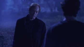 Movie still from “Hellraiser: Hellworld” (2005), directed by Rick Bota – An older man in a black jacket looking at a younger man; Medium shot, Over the shoulder angle