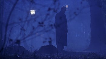 Movie still from “Hellraiser: Hellworld” (2005), directed by Rick Bota – A man standing in a field at night with trees in the background; Wide shot, Over the shoulder angle