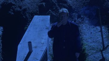 Movie still from “Hellraiser: Hellworld” (2005), directed by Rick Bota – A man standing in front of a wooden bench; Medium shot, High angle