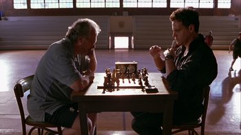 Movie still from “Hellraiser: Inferno” (2000), directed by Scott Derrickson – Two men are playing a game of chess in a gymnasium; Medium shot, High angle