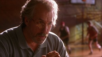 Movie still from “Hellraiser: Inferno” (2000), directed by Scott Derrickson – An older man wearing glasses looking at the camera; Close Up shot, Over the shoulder angle