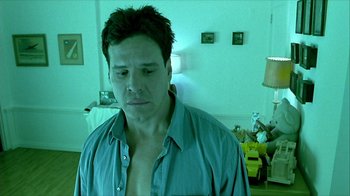 Movie still from “Hellraiser: Inferno” (2000), directed by Scott Derrickson – A person wearing a blue shirt in a room; Close Up shot, Low angle