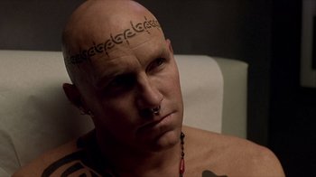 Movie still from “Hellraiser: Inferno” (2000), directed by Scott Derrickson – A bald man with tattoos on his head; Close Up shot, High angle
