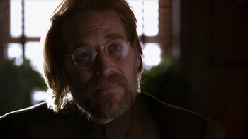 Movie still from “Hellraiser: Inferno” (2000), directed by Scott Derrickson – A person with a beard wearing glasses; Close Up shot, Over the shoulder angle