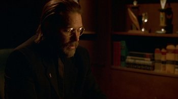 Movie still from “Hellraiser: Inferno” (2000), directed by Scott Derrickson – A man with long hair and glasses sitting in a dark room; Close Up shot, Over the shoulder angle