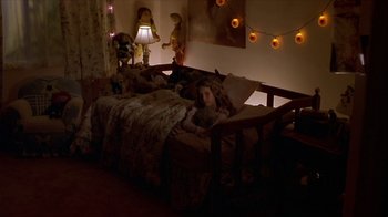Movie still from “Hellraiser: Inferno” (2000), directed by Scott Derrickson – A child laying on a bed in a room; Wide shot, High angle