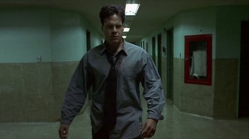 Movie still from “Hellraiser: Inferno” (2000), directed by Scott Derrickson – A man wearing a tie walking down a hall way; Medium shot, Low angle