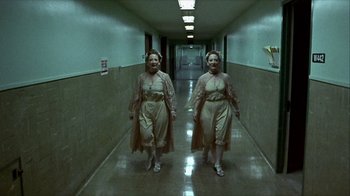 Movie still from “Hellraiser: Inferno” (2000), directed by Scott Derrickson – A couple of people that are walking down a hall way; Wide shot, Low angle