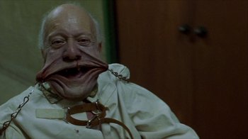 Movie still from “Hellraiser: Inferno” (2000), directed by Scott Derrickson – An old man with a fake nose and a chain around his mouth; Close Up shot, Low angle