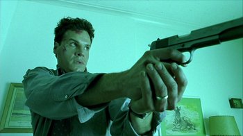 Movie still from “Hellraiser: Inferno” (2000), directed by Scott Derrickson – A man holding a gun in a room; Close Up shot, Low angle