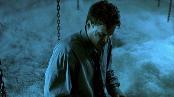 Movie still from “Hellraiser: Inferno” (2000), directed by Scott Derrickson – A young man in a blue shirt and tie; Medium shot, High angle