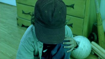 Movie still from “Hellraiser: Inferno” (2000), directed by Scott Derrickson – A person wearing a hat sitting on a bench; Close Up shot, High angle