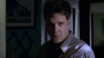 Movie still from “Hellraiser: Inferno” (2000), directed by Scott Derrickson – A person wearing a gray shirt; Close Up shot, Over the shoulder angle