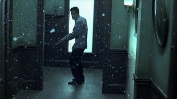 Movie still from “Hellraiser: Inferno” (2000), directed by Scott Derrickson – A man standing in a room holding a gun in his hand; Wide shot, Low angle