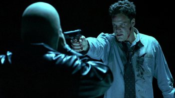 Movie still from “Hellraiser: Inferno” (2000), directed by Scott Derrickson – A man holding a gun pointed at another man; Close Up shot, Over the shoulder angle