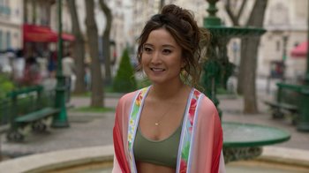 Movie still from “Emily in Paris” (2020), created by Darren Star – A beautiful young lady wearing a green bikini top; Medium shot, Over the shoulder angle