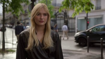 Movie still from “Emily in Paris” (2020), created by Darren Star – A woman with long blonde hair standing on the sidewalk; Close Up shot, Over the shoulder angle