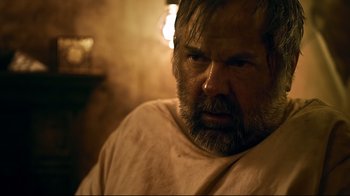 Movie still from “Hellraiser: Judgment” (2018), directed by Gary J. Tunnicliffe – A man with a goatee and a beard stares at the camera; Close Up shot, Over the shoulder angle