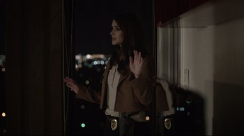 Movie still from “Hellraiser: Judgment” (2018), directed by Gary J. Tunnicliffe – A woman standing in front of a window at night; Medium shot, Over the shoulder angle