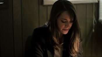 Movie still from “Hellraiser: Judgment” (2018), directed by Gary J. Tunnicliffe – A woman sitting in a chair looking down at a laptop; Close Up shot, Low angle