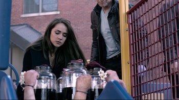 Movie still from “Hellraiser: Judgment” (2018), directed by Gary J. Tunnicliffe – A woman looking at a jar of flowers; Medium shot, Over the shoulder angle