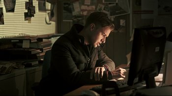 Movie still from “Hellraiser: Judgment” (2018), directed by Gary J. Tunnicliffe – A man sitting in front of a computer in an office; Medium shot, Low angle