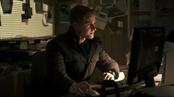 Movie still from “Hellraiser: Judgment” (2018), directed by Gary J. Tunnicliffe – A man sitting in front of a computer keyboard; Medium shot, Low angle