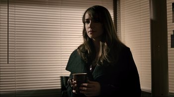 Movie still from “Hellraiser: Judgment” (2018), directed by Gary J. Tunnicliffe – A woman is holding a cup of coffee in her hands; Medium shot, Over the shoulder angle