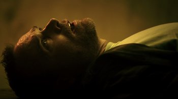 Movie still from “Hellraiser: Judgment” (2018), directed by Gary J. Tunnicliffe – A man with a beard laying on a bed; Close Up shot, Overhead angle