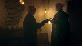 Movie still from “Hellraiser: Judgment” (2018), directed by Gary J. Tunnicliffe – Two people in a room with a light bulb; Medium shot, Over the shoulder angle