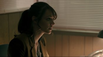 Movie still from “Hellraiser: Judgment” (2018), directed by Gary J. Tunnicliffe – A beautiful young lady sitting in front of a window; Close Up shot, Over the shoulder angle