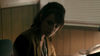 Movie still from “Hellraiser: Judgment” (2018), directed by Gary J. Tunnicliffe – A woman in a yellow jacket is looking at the camera; Close Up shot, Over the shoulder angle