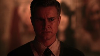 Movie still from “Hellraiser: Judgment” (2018), directed by Gary J. Tunnicliffe – A person wearing a suit and tie; Close Up shot, Over the shoulder angle