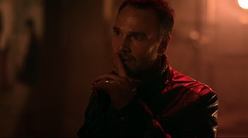 Movie still from “Hellraiser: Judgment” (2018), directed by Gary J. Tunnicliffe – A man in a red shirt is holding his hand to his face; Close Up shot, Over the shoulder angle