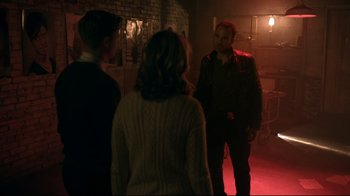 Movie still from “Hellraiser: Judgment” (2018), directed by Gary J. Tunnicliffe – A group of people standing around in a room; Medium shot, Over the shoulder angle