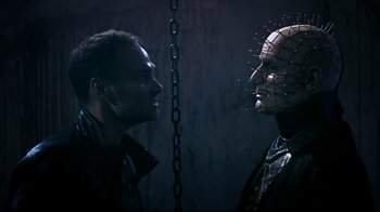 Movie still from “Hellraiser: Judgment” (2018), directed by Gary J. Tunnicliffe – Two men face to face in front of a chain; Close Up shot, Low angle