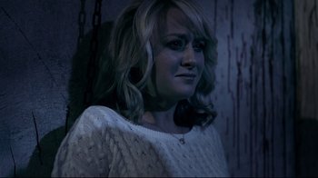 Movie still from “Hellraiser: Judgment” (2018), directed by Gary J. Tunnicliffe – A young woman with blonde curly hair wearing a white sweater; Close Up shot, Over the shoulder angle