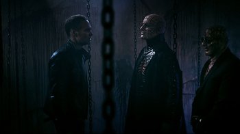 Movie still from “Hellraiser: Judgment” (2018), directed by Gary J. Tunnicliffe – Two men standing next to each other in chains; Medium shot, Over the shoulder angle