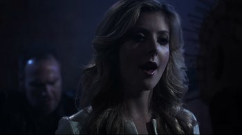 Movie still from “Hellraiser: Judgment” (2018), directed by Gary J. Tunnicliffe – A woman with long blonde hair is looking at the camera; Close Up shot, Over the shoulder angle