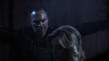 Movie still from “Hellraiser: Judgment” (2018), directed by Gary J. Tunnicliffe – A man and a woman in a dark room; Medium shot, Over the shoulder angle