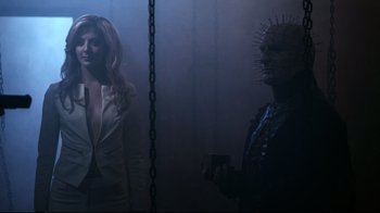 Movie still from “Hellraiser: Judgment” (2018), directed by Gary J. Tunnicliffe – A woman in a white jacket and a man in a black suit; Medium shot, Low angle