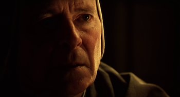 Movie still from “Henry V” (1989), directed by Kenneth Branagh – An old man with a beard is looking at the camera; Close Up shot, Over the shoulder angle