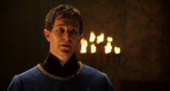 Movie still from “Henry V” (1989), directed by Kenneth Branagh – A man in a blue and gold uniform in front of candles; Close Up shot, Low angle