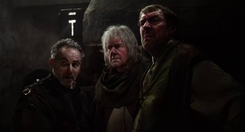 Movie still from “Henry V” (1989), directed by Kenneth Branagh – A group of men standing next to each other in a room; Medium shot, Low angle