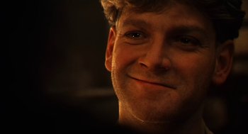 Movie still from “Henry V” (1989), directed by Kenneth Branagh – A man smiling for the camera; Close Up shot, Low angle