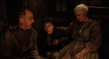 Movie still from “Henry V” (1989), directed by Kenneth Branagh – A group of people sitting on the ground; Medium shot, High angle