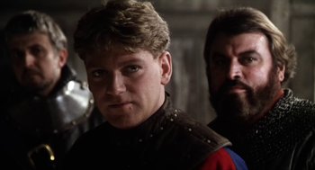 Movie still from “Henry V” (1989), directed by Kenneth Branagh – A man in a leather jacket and another man in a beard; Close Up shot, Over the shoulder angle
