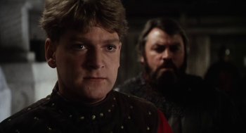 Movie still from “Henry V” (1989), directed by Kenneth Branagh – Two men in medieval garb looking at the camera; Close Up shot, Low angle