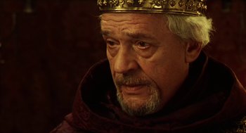 Movie still from “Henry V” (1989), directed by Kenneth Branagh – An older man wearing a crown and a red robe; Close Up shot, Low angle