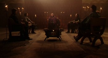 Movie still from “Henry V” (1989), directed by Kenneth Branagh – A group of people standing around a fire pit; Wide shot, High angle